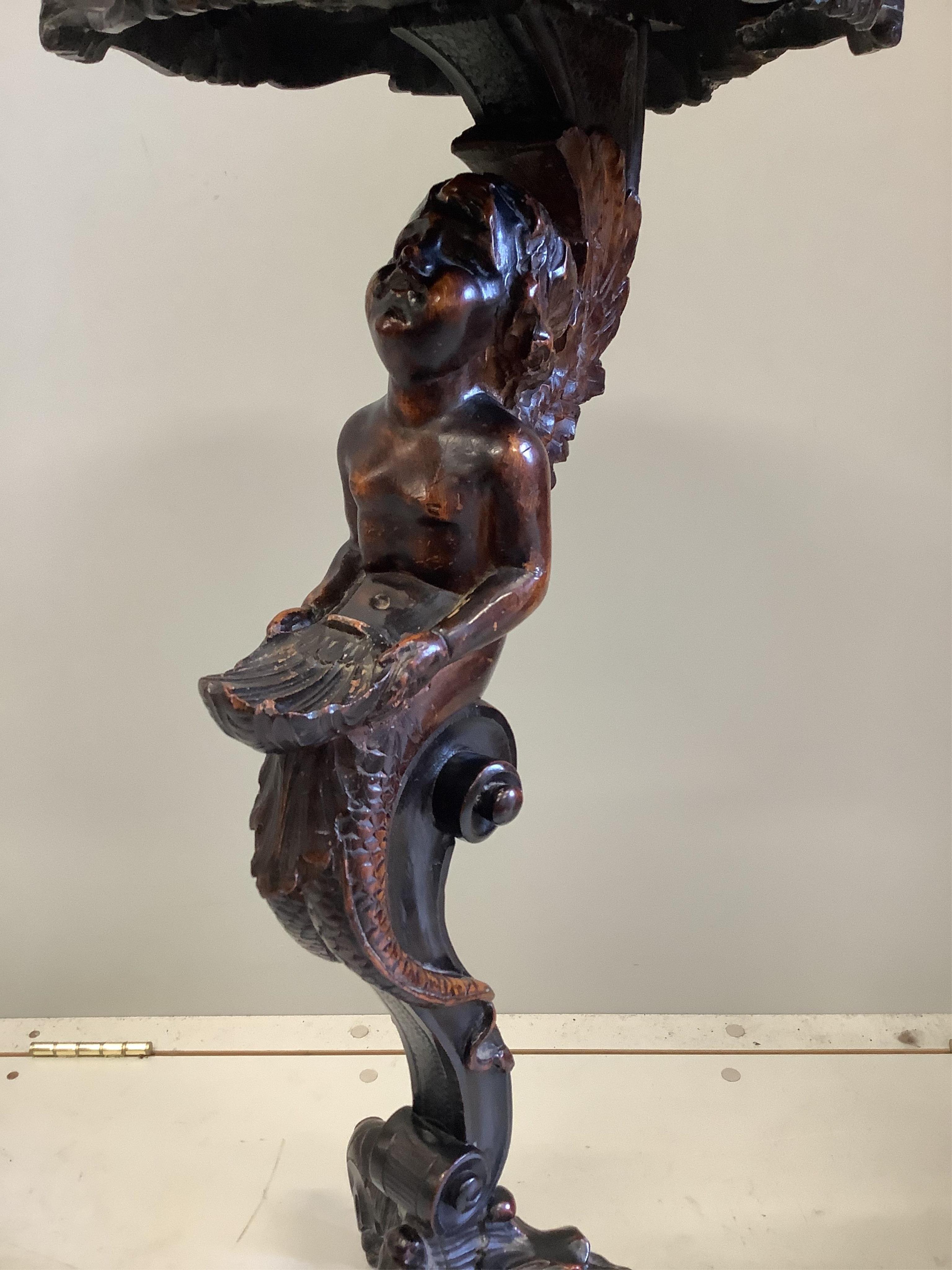 An Italian carved walnut cherub and shell torchere, height 81cm. Condition - good